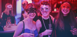 A few women wearing masks for a costume masquerade party