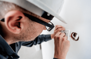 An electrician working on an electric outlet