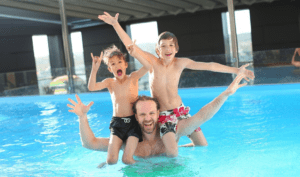 family playing in swimming pool