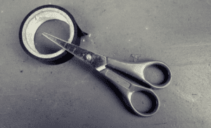 a pair of scissors and a roll of black tape