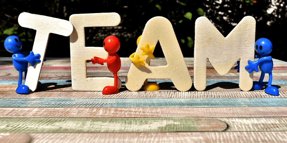 wooden letters spelling out team with figurines 