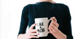 A female holding a "boss" themed mug