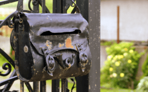 A metal mailbox in the shape of a handbag