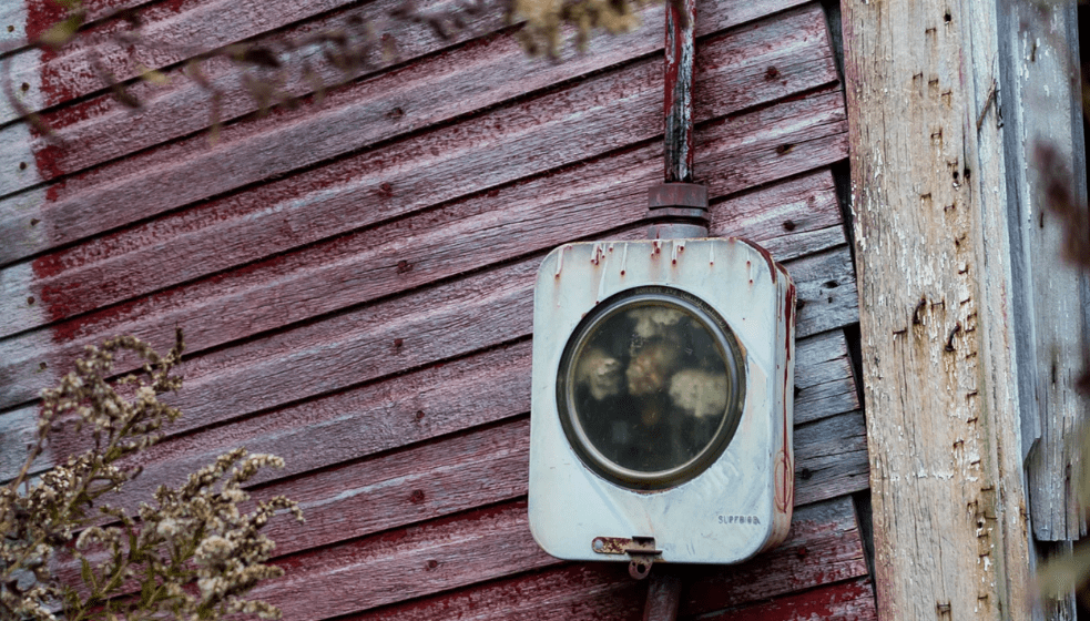 An old electric meter against an old building