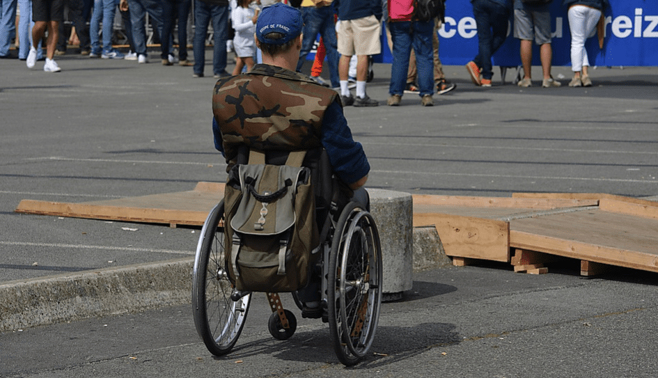 Man sitting in a wheelchair with camouflage vest