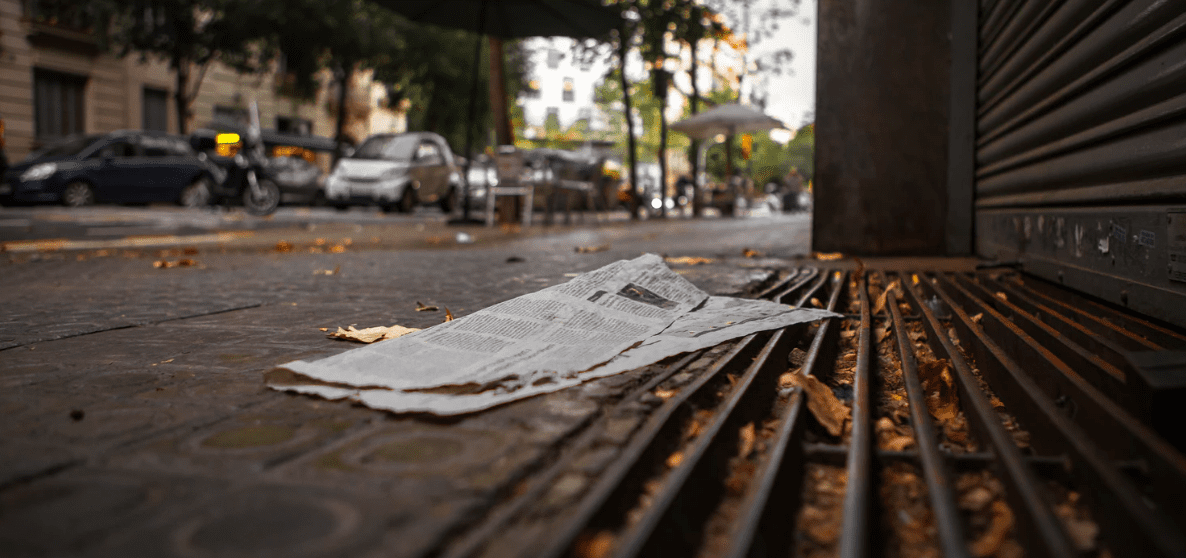 Newspaper on the ground of a sidewalk