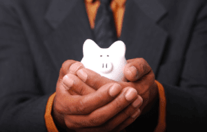 A man holding a small piggy bank in his hands