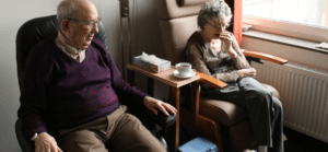 A senior citizen couple sitting down