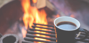 Coffee brewing in a mug over a firepit