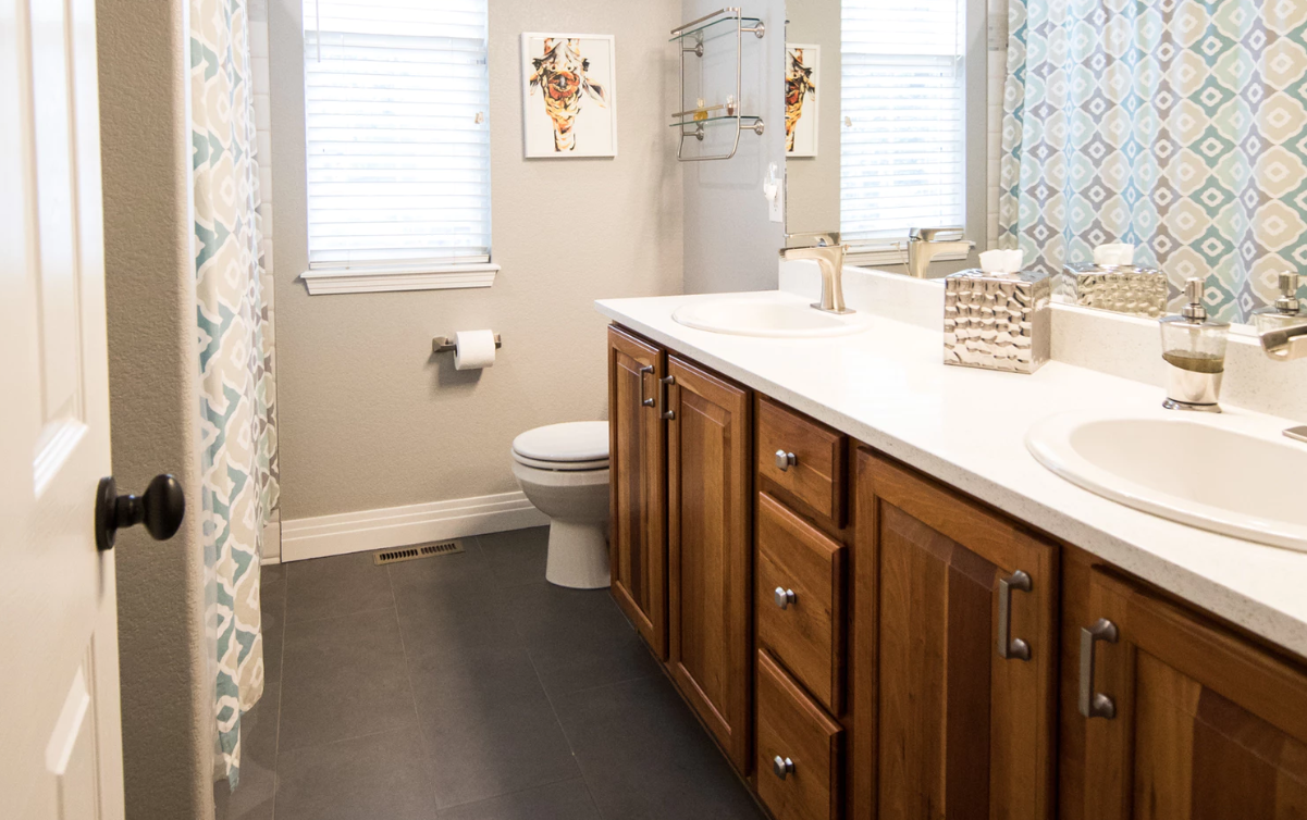 Tidy bathroom with brown cabinets and white countertop