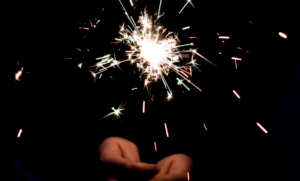 Person holding lit sparkler f