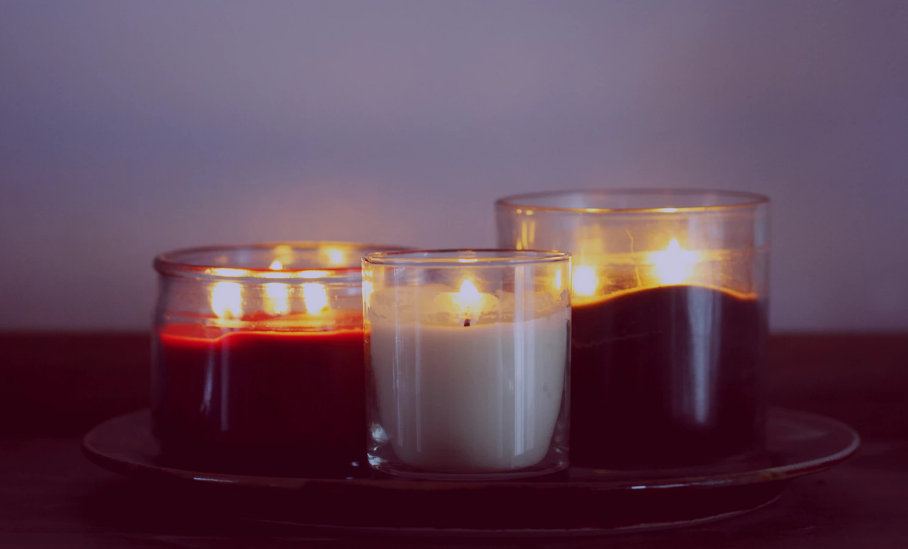 Three lit candles in jars