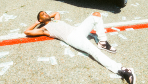 Man lying down on the road with cash