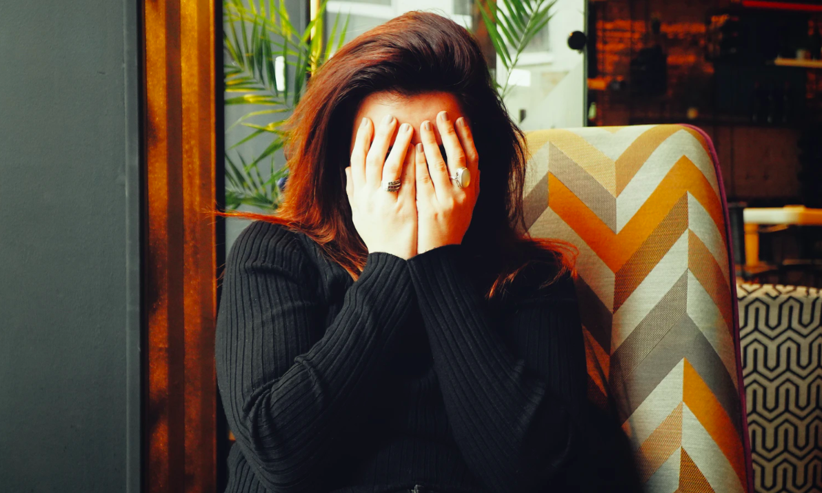A woman covering her eyes with her hands